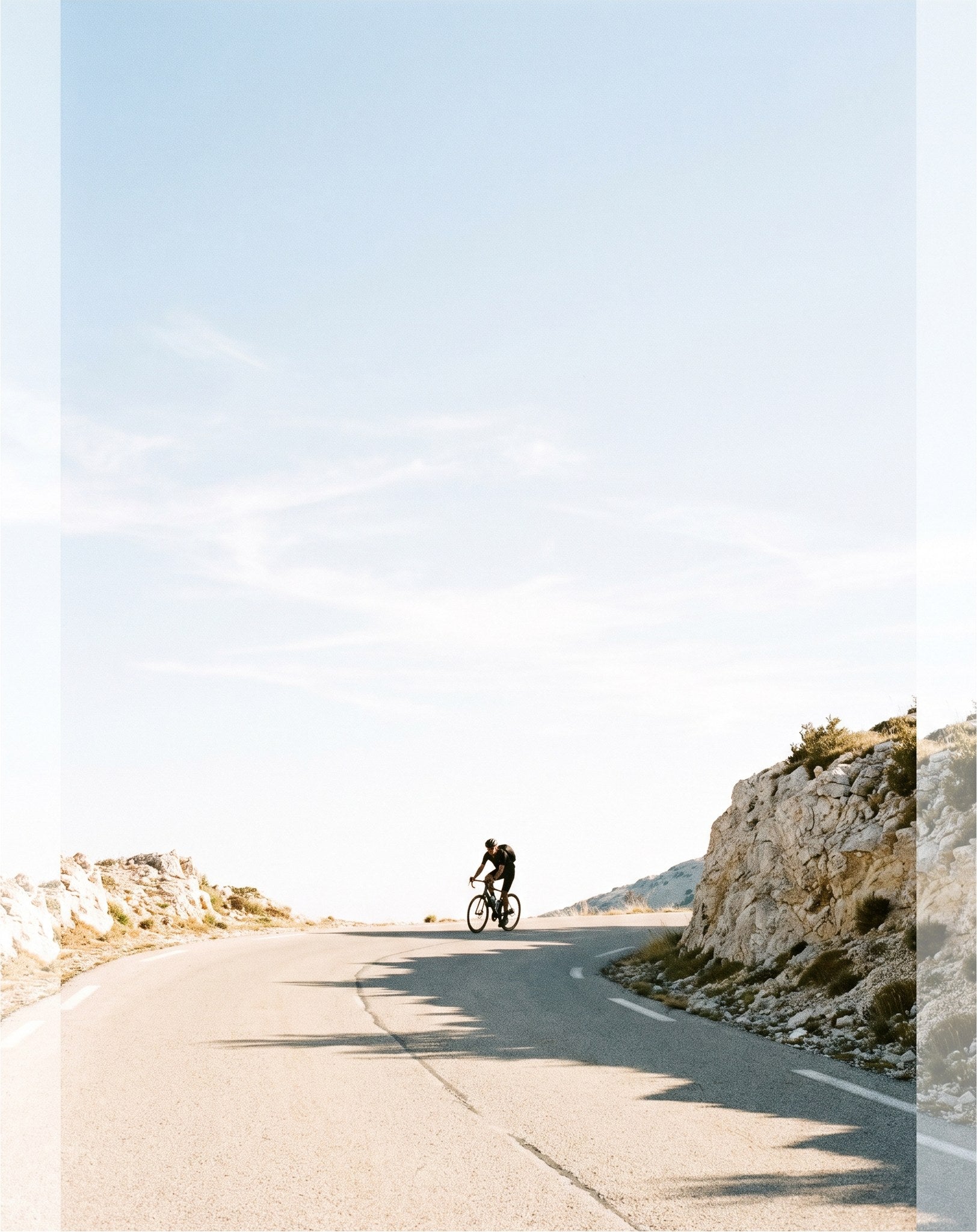 Cyclist on a long mountain road climb under open sky